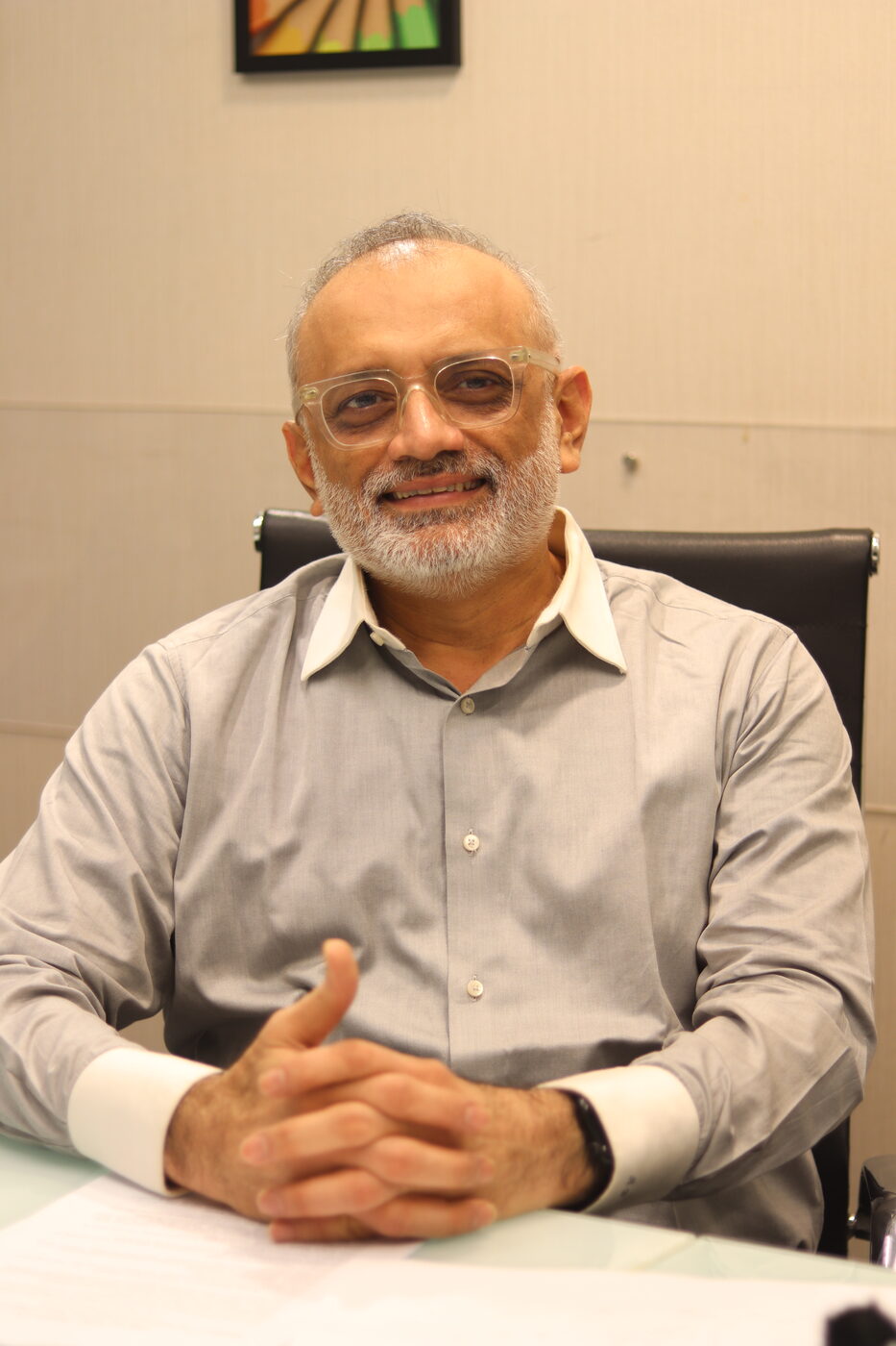 Abhijit Bhave at his desk, smiling